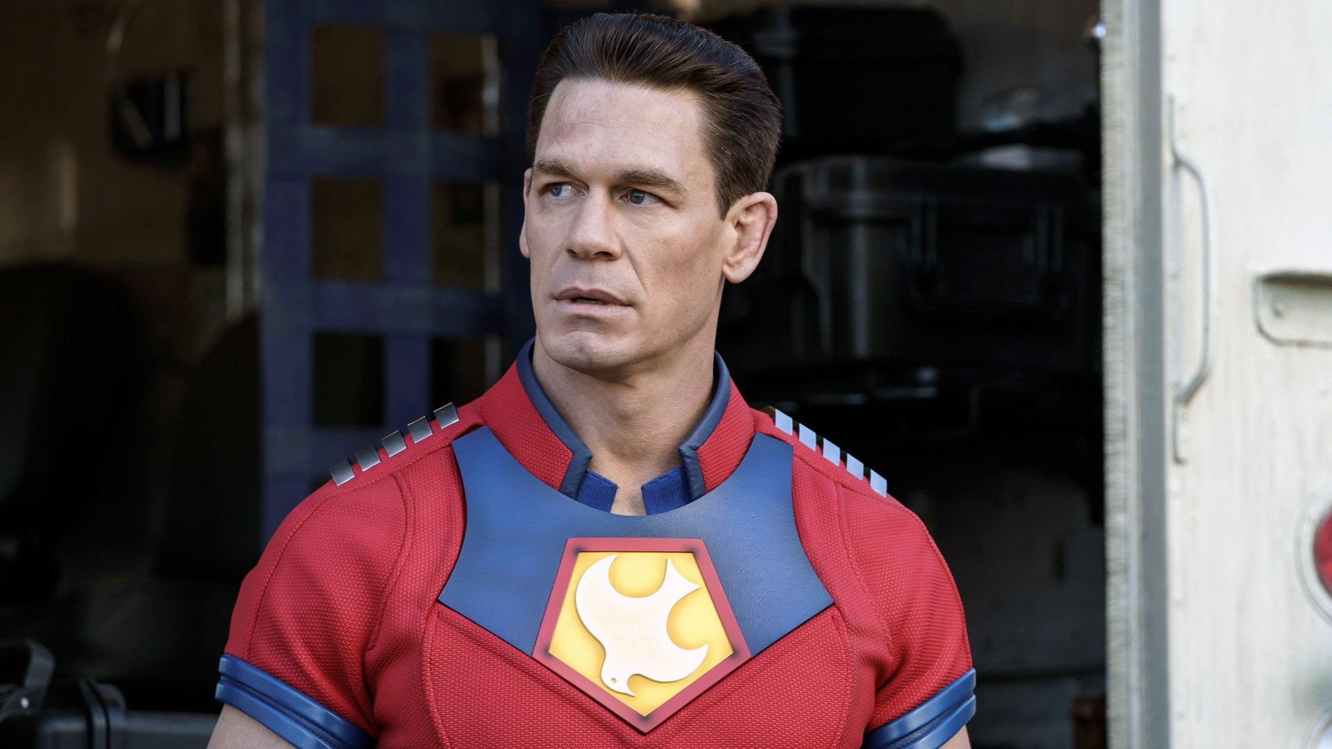 Peacemaker looks at something off-screen.